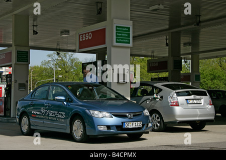 Honda Civic Hybrid et la Toyota Prius, l'année de modèle 2006, d'argent, debout, à la défense, de la ville, station d'essence, hybride d'env. Banque D'Images