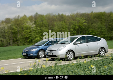 Honda Civic Hybrid et la Toyota Prius, l'année de modèle 2006, d'argent, la conduite, la diagonale de l'avant, vue latérale, country road, hybride Banque D'Images