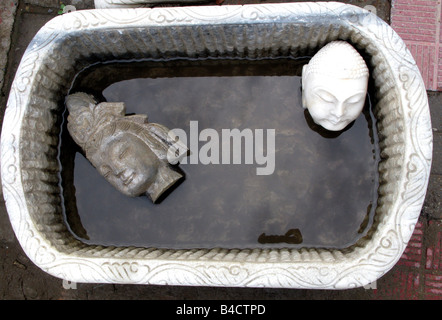 Deux têtes de Bouddha dans un bol d'eau dans le marché aux puces de Panjiayuan, Beijing, Chine Banque D'Images