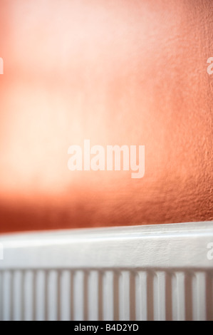 Radiateur peint en blanc sur fond rouge Banque D'Images