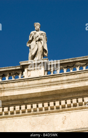 Statues de marbre au sommet d'énormes colonnes entourent Piaaza San Pietro à St basilique Saint-Pierre à Rome, Italie Banque D'Images