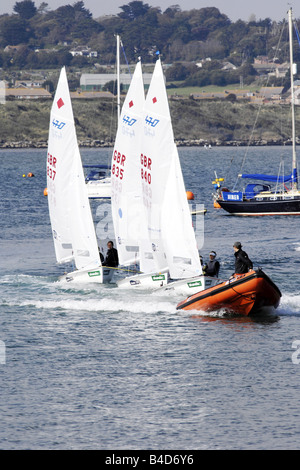 Les tuteurs de l'Académie de voile des Jeux olympiques de leurs étudiants de remorquage retour à la marina de Portland après une leçon Banque D'Images