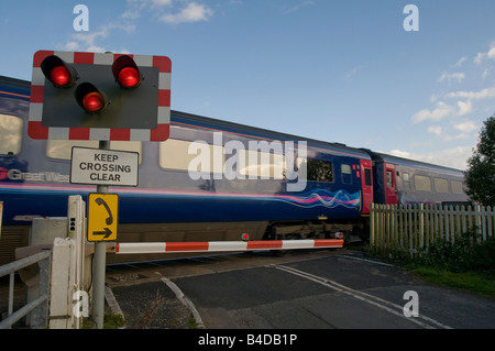 First Great Western train de passagers se déplaçant à vitesse mais un passage à niveau automatique Banque D'Images