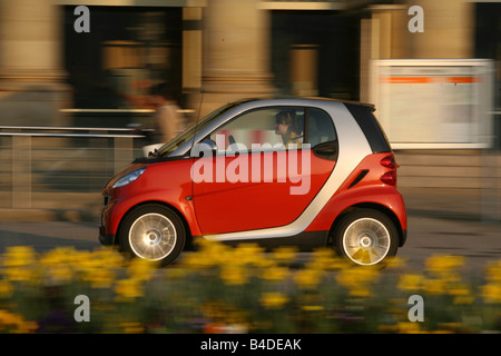 Smart fortwo Passion, modèle de l'année 2007-, rouge, au volant, côté, vue sur la ville Banque D'Images