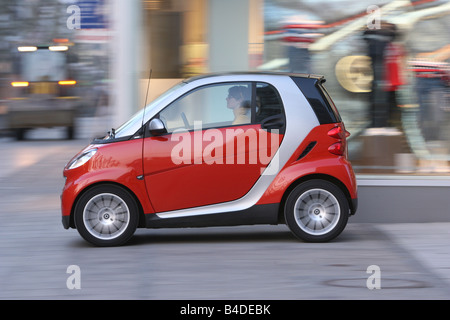 Smart fortwo Passion, modèle de l'année 2007-, rouge, au volant, côté, vue sur la ville Banque D'Images