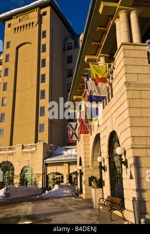 Fairmont Chateau Lake Louise avec les drapeaux des nations survolant entrée sur journée d'hiver ensoleillée Banque D'Images