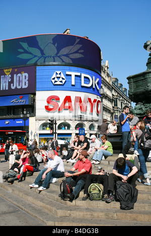 Les touristes reste sur mesures en vertu de l'Eros statue fontaine de Piccadilly Circus avec de célèbres enseignes publicitaire néon derrière date majeure Banque D'Images