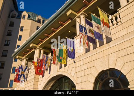 Fairmont Chateau Lake Louise avec les drapeaux des nations survolant entrée sur journée d'hiver ensoleillée Banque D'Images