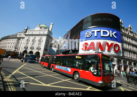 Longueur double Red London bus bendy passe devant de célèbres enseignes néon dans Piccadilly Circus Londres monument touristique UK Banque D'Images