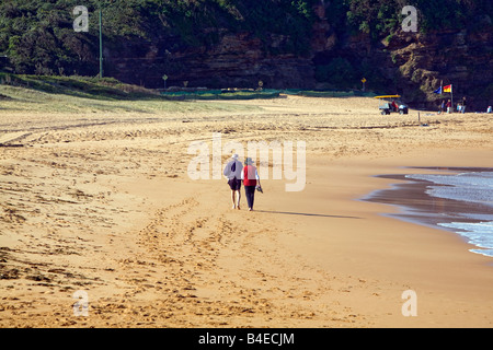 Vue arrière d'un couple de personnes âgées marchant le long de la plage de Bilgola, plages du nord, Sydney, Nouvelle-Galles du Sud, Australie Banque D'Images