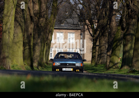 Location, Renault Fuego, l'année de modèle 1984 env., bleu, ancienne, années 80, années 80, la conduite, la vue avant, route, chemin de campagne, photographie Banque D'Images