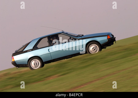 Location, Renault Fuego, l'année de modèle 1984 env., bleu, ancienne, années 80, années 80, la conduite, la vue de côté, route, chemin de campagne, photographe Banque D'Images