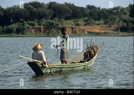 Les pêcheurs locaux de net casting en mer bateau lac calme. L'Ouganda. Banque D'Images