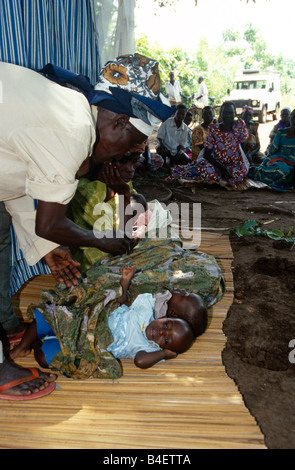 Les villageois attendent de voir le sorcier-docteur, Ouganda Banque D'Images