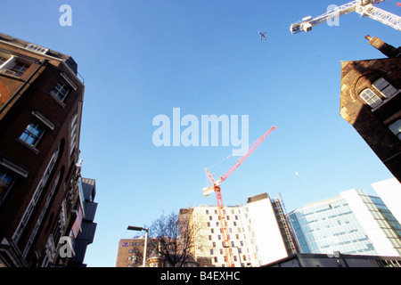 Un avion volant au-dessus d'un site de construction à Londres. Banque D'Images