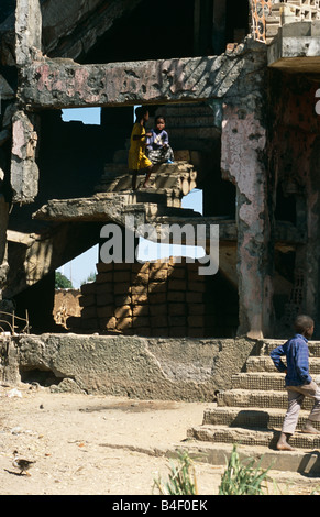 Les enfants sans-abri dans un bâtiment détruit par la guerre en Angola. Banque D'Images