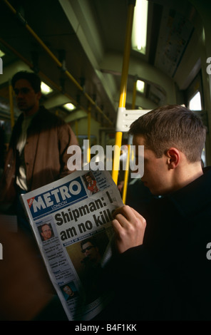 Man reading newspaper dans train, Londres, Angleterre, Royaume-Uni Banque D'Images