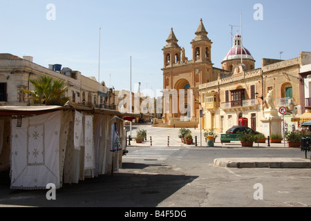 Les étals de marché et l'église à côté du port de Marsaxlokk, village de Malte. Banque D'Images