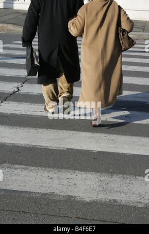 Vieux couple crossing Road dans la ville de la ville Banque D'Images