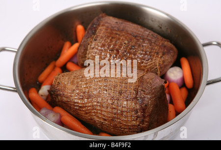 Les joints de boeuf rond doré prêt à rôtir pot braiser dans une cocotte avec les carottes et l'échalote Banque D'Images