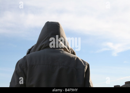 Personne qui porte manteau capuche veste et ciel bleu Banque D'Images