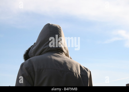 Personne qui porte manteau capuche veste et ciel bleu Banque D'Images