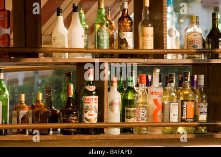 Les bouteilles d'alcool dans une rangée sur une étagère de bar Banque D'Images