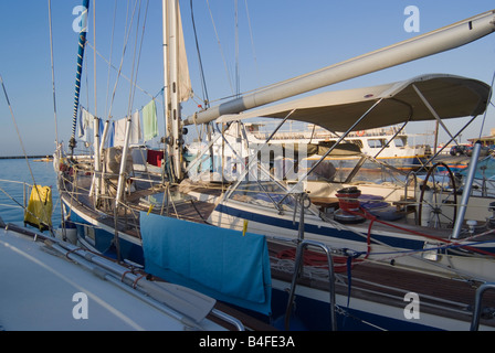 Lave-linge en train de sécher dehors tôt le matin soleil sur yachts dans le port de la ville de Tinos Cyclades Grèce Mer Egée Banque D'Images