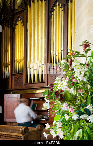 Homme jouant de l'orgue dans l'église du village de St.Mary's au Bishops Canning, Wiltshire, Angleterre, Grande-Bretagne, Royaume-Uni Banque D'Images