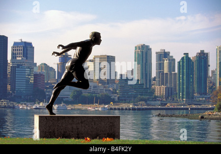 La statue d'un d'athelete olympique et les toits de la ville de Stanley Park, Vancouver British Columbia, Canada. Banque D'Images