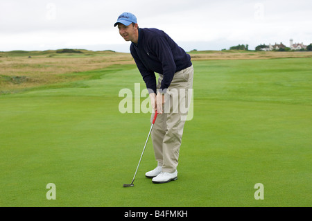 Golfeur professionnel alignement d'un putt sur le green (partie d'une série) Banque D'Images