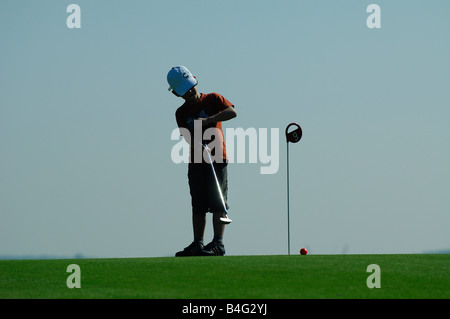 Un jeune golfeur de jouer un golf sur un green de golf - France Banque D'Images