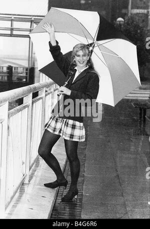 L'actrice Imogen Stubbs holding up parapluie dans la pluie et forme Banque D'Images