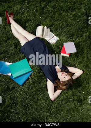 Une jeune fille allongé dans l'herbe Banque D'Images