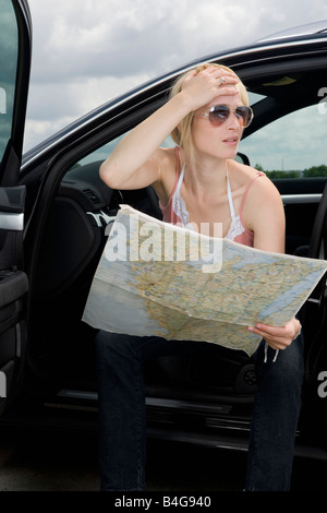 Une femme lisant une feuille de route et à la confus Banque D'Images