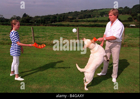 William Roache acteur jouant avec sa fille et leur chien dans le jardin arrière Bill qui joue Ken Barlow dans le Feuilleton Coronation Street Banque D'Images