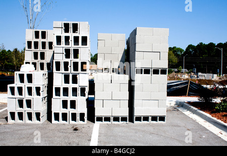 Des piles de briques de construction en béton blanc sur un site de construction dans un parc de stationnement Banque D'Images