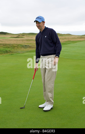 Golfeur professionnel alignement d'un putt sur le green (partie d'une série) Banque D'Images