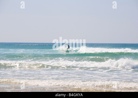 Seul surfer une vague au centre du châssis avec des couleurs mer saturée sur la plage de Fistral Newquay, Cornwall Royaume Uni Banque D'Images
