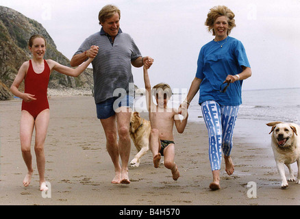 William Roache acteur qui joue Ken Barlow dans Coronation Streert Programme tv en cours d'exécution sur plage avec sa famille en vacances Banque D'Images