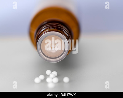 Close-up of pills homéopathiques de répandre de la bouteille Banque D'Images