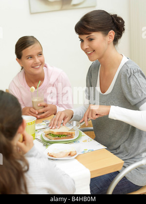 La mère et les filles ayant le petit déjeuner Banque D'Images