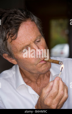 Homme d'âge moyen fumer un cigare Banque D'Images