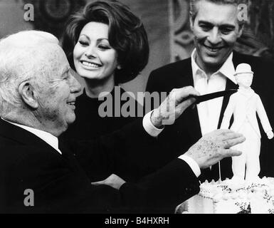 L'Acteur Charlie Chaplin fête ses 77 ans de couper un gâteau avec l'actrice Sophia Loren et son fils Sydney Banque D'Images