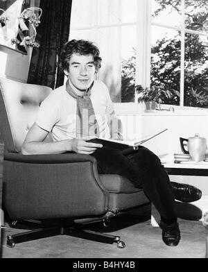 L'Acteur Ian Mckellen Octobre 1969 Photographié assis dans un fauteuil avec un livre sur ses genoux Banque D'Images