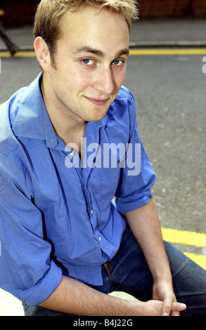 Chris Oliver acteur vu ici se détendre avant le début du tournage d'une nouvelle série de fiction pour Carlton TV Blue Shirt Denim Jeans assis sur bollard Juillet 2004 Mirrorpix Mirrorpix Banque D'Images