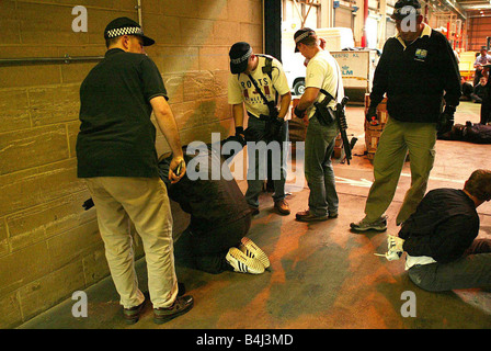 Policiers armés et des vols suspects sur les lieux d'une tentative de 30 millions de livres au raid bullion Swissport près de l'aéroport d'Heathrow, juin 2005 déjoué Gold Bullion à main armée en 2000 sBULLION à Heathrow HEATHROW SWISSPORT RAID RAIDERS D'ÊTRE ARRÊTÉ PAR LA POLICE ARMÉE Juin 2005 vol de lingots d'étain à Heathrow Années 2000 mirrorpix Banque D'Images