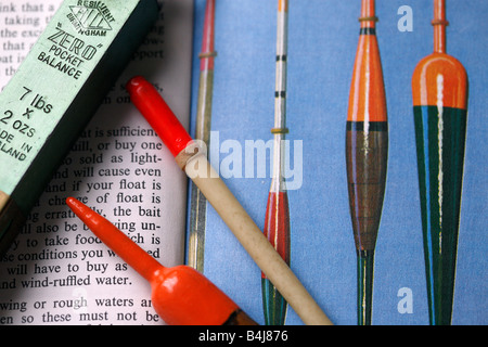 Flotteurs pêche vintage, niché entre les pages de vieux livre sur la pêche à la ligne. Banque D'Images