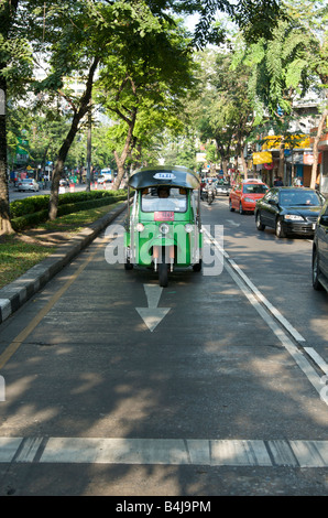 Un tuk tuk ou pousse-pousse motorisés de s'immobiliser à un ensemble de feux de circulation Bangkok Thaïlande Banque D'Images