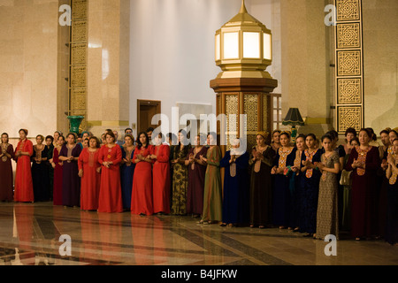 Audience de la femme en costume national à l'ouverture de conférence internationale dans le Musée du Président, Ashqabat, Turkménistan Banque D'Images